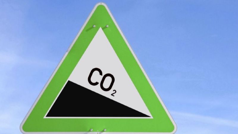Das Bild zeigt ein Verkehrsschild das einen abschüssigen CO2-Weg darstellt.