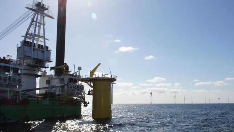 Auf dem Meer wird eine Offshore-Windenergieanlage aufgebaut.