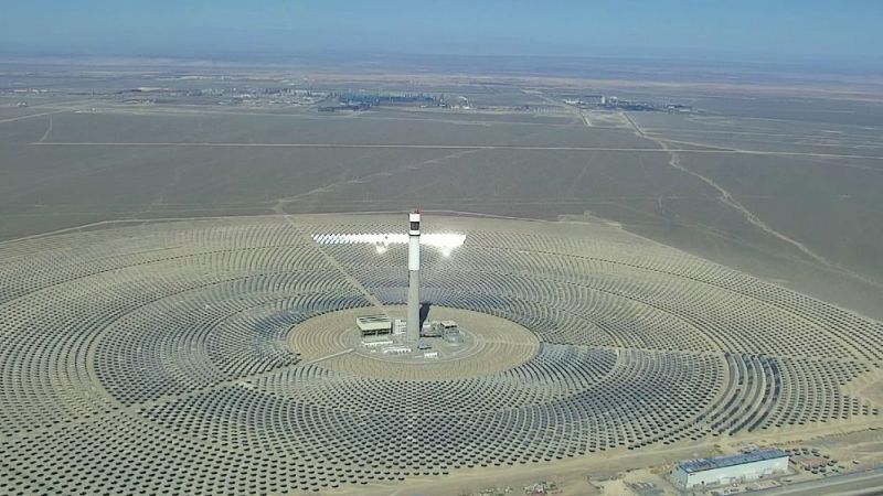 Ein Solarturmkraftwerk, zahlreiche Heliostaten sind um einen Solarturm gruppiert.