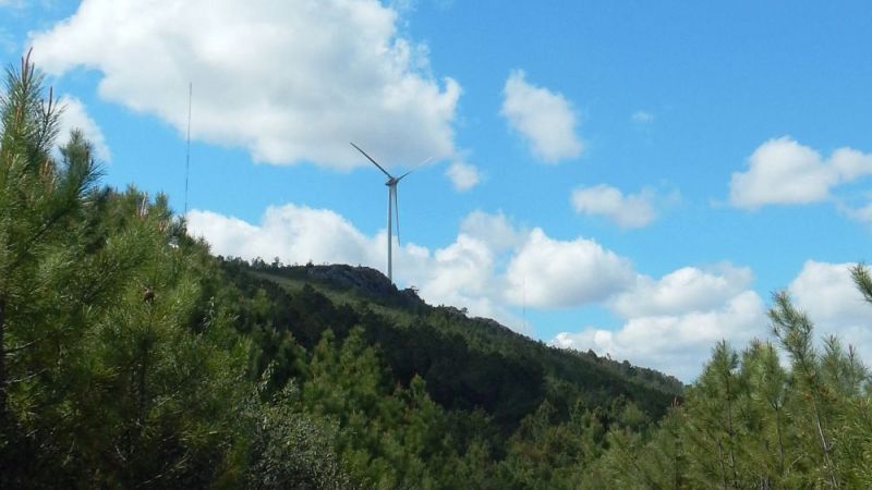 The photo shows an ENERCON wind turbine on a hill.