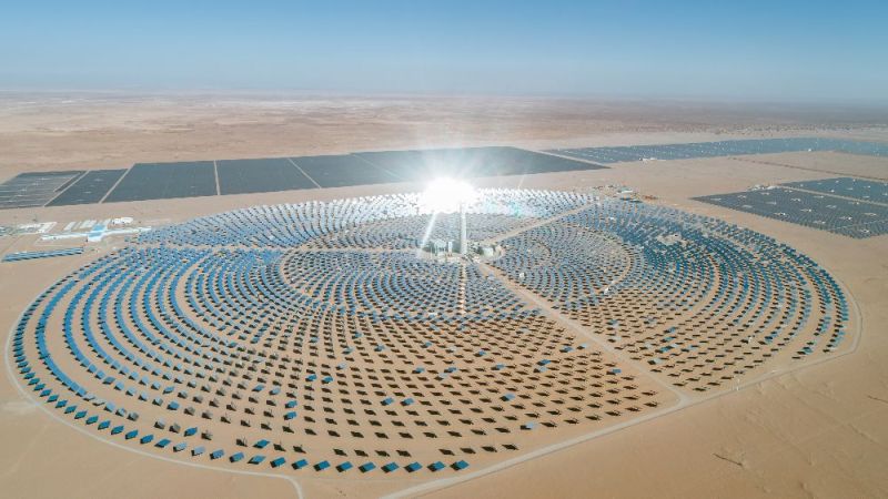 A solar tower power plant stands in the desert.