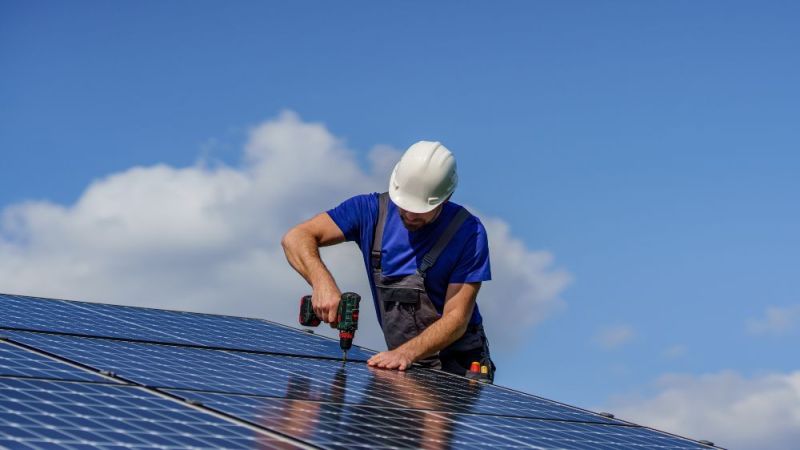 Symbolfoto: Arbeiter bei der Installation von Solarzellen auf einem Dach.