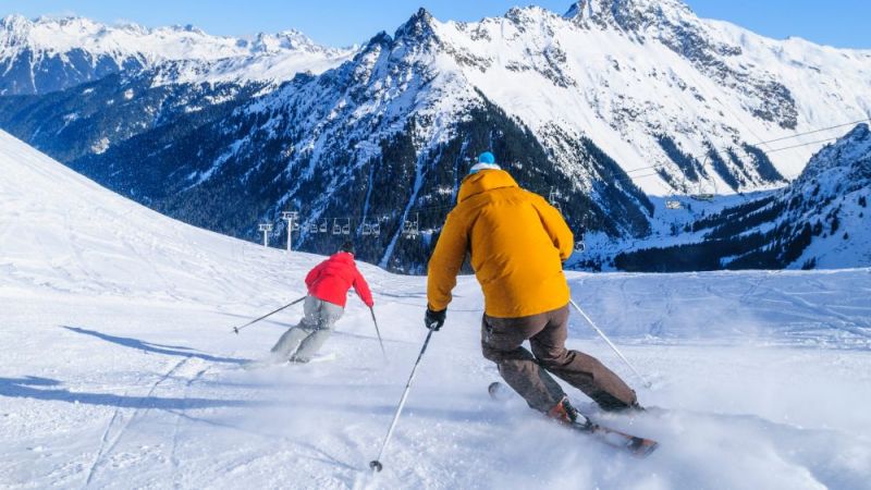 Symbolfoto: Skifahrer in bergiger Schneelandschaft.