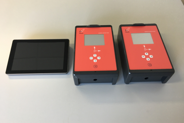 Two boxes with red control panel plus black display. Next to it is a tablet.