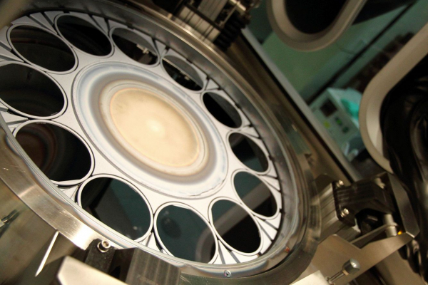 View into an epitaxy reactor with germanium wafers. The multi-junction solar cells are produced in the reactor.