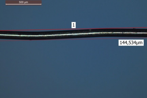 The photo shows a microscopic image of a structured wire.